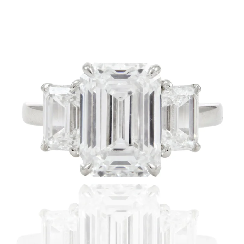 PLATINUM THREE-STONE ENGAGEMENT RING WITH A 5.03CT CENTER EMERALD-CUT DIAMOND AND EMERALD SIDES 2.05CTW