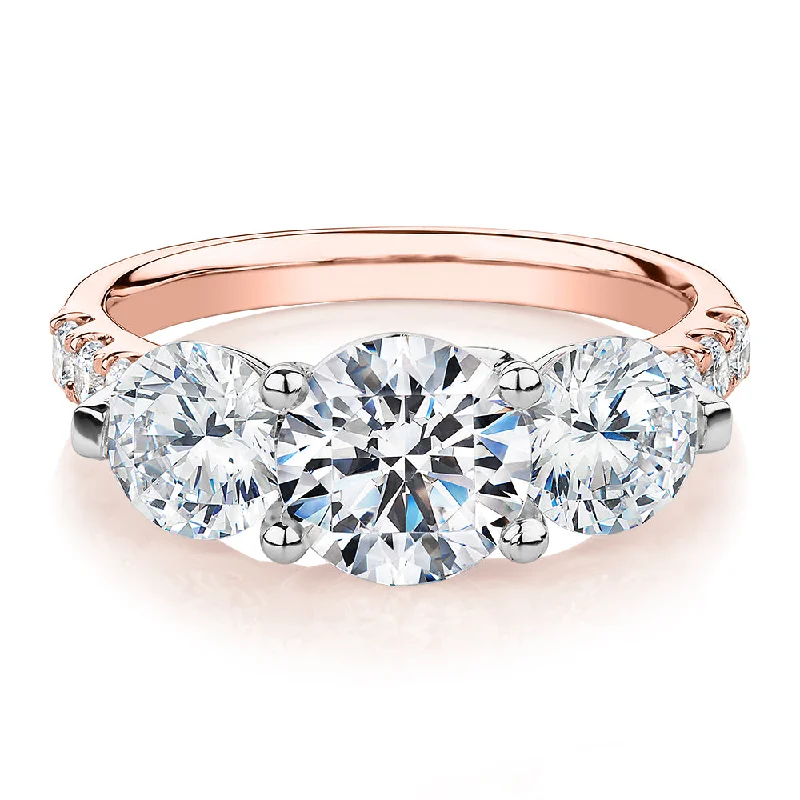 Three stone ring with 3.59 carats* of diamond simulants in 10 carat rose and white gold