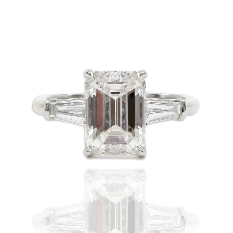 PLATINUM EMERALD-CUT DIAMOND AND TAPERED BAGUETTE THREE-STONE ENGAGEMENT RING