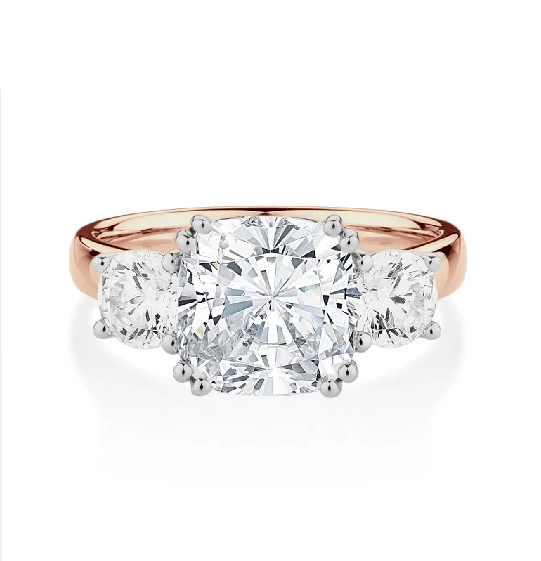 Three stone ring with 3.75 carats* of diamond simulants in 10 carat rose and white gold